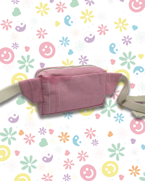 A pink canvas fanny pack with a beige strap. 