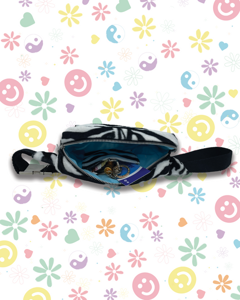 A black and white zebra print bumbag with a blue interior lining, shown open. 