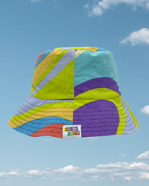 Rainbow swirl bucket hat showing Buckets & Bums woven label